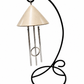 An indoor solar wind chime  with a champagne mist colored top with a black metal  stand ready for a sunny window sill or table
