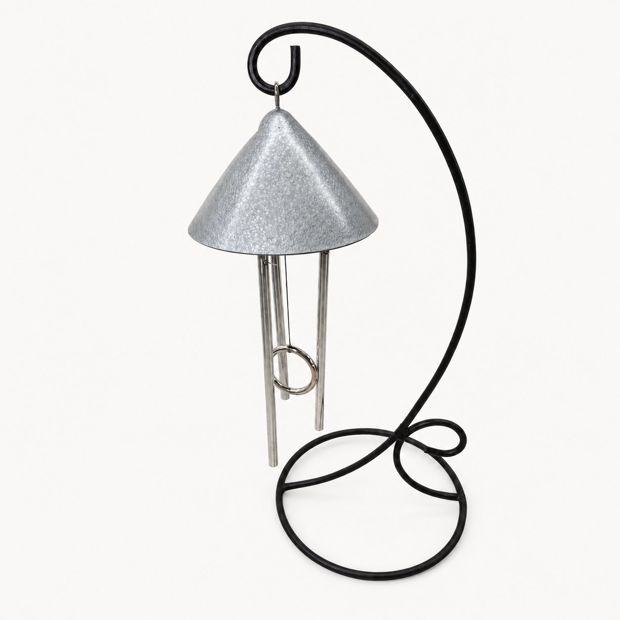 An indoor pewter colored solar wind chime featuring a textured silver metal cone-shaped top and three silver hanging rods, supported by a curved black metal stand